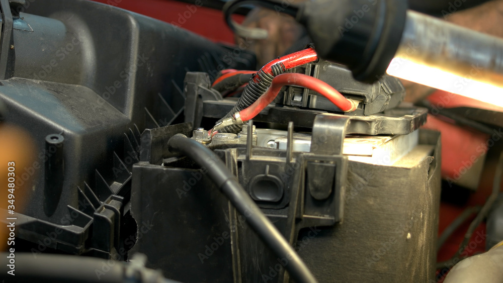 Close up car battery. Mechanic in a car service fixing car accumulator.