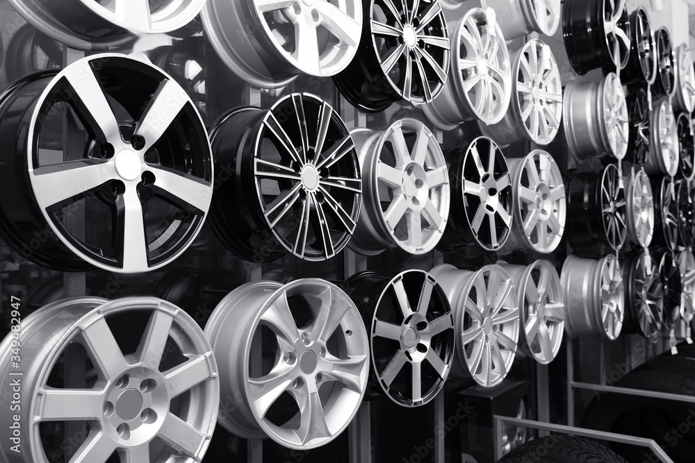 Fototapeta premium Alloy wheels on rack in auto store. Black and white effect