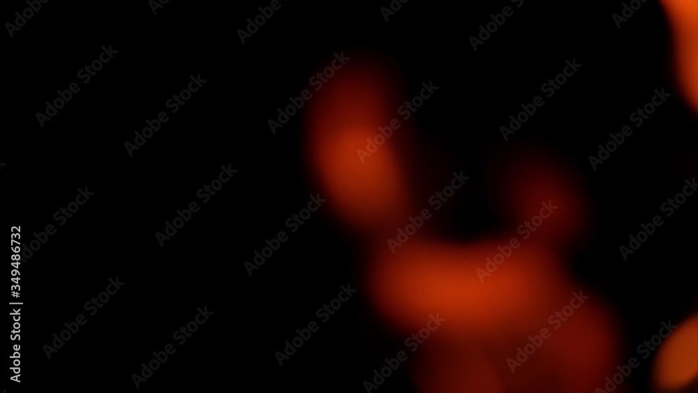 Blur orange fire that burns in slow motion in the dark. Bright, unfocused fire on the right side of the image on a black background. Blur orange fire that burns in slow motion in the dark. Bright, unfocused fire on the right side of the image on a black background.