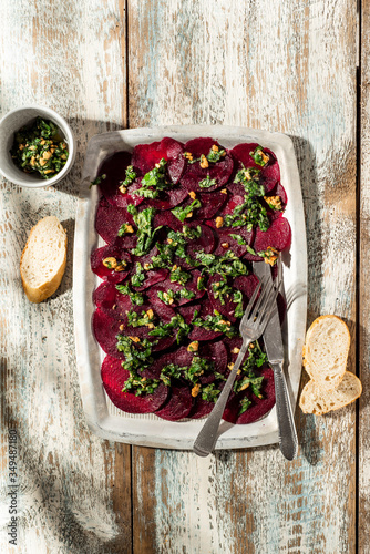 Beetroot carpaccio with walnuts and herbs dressing.