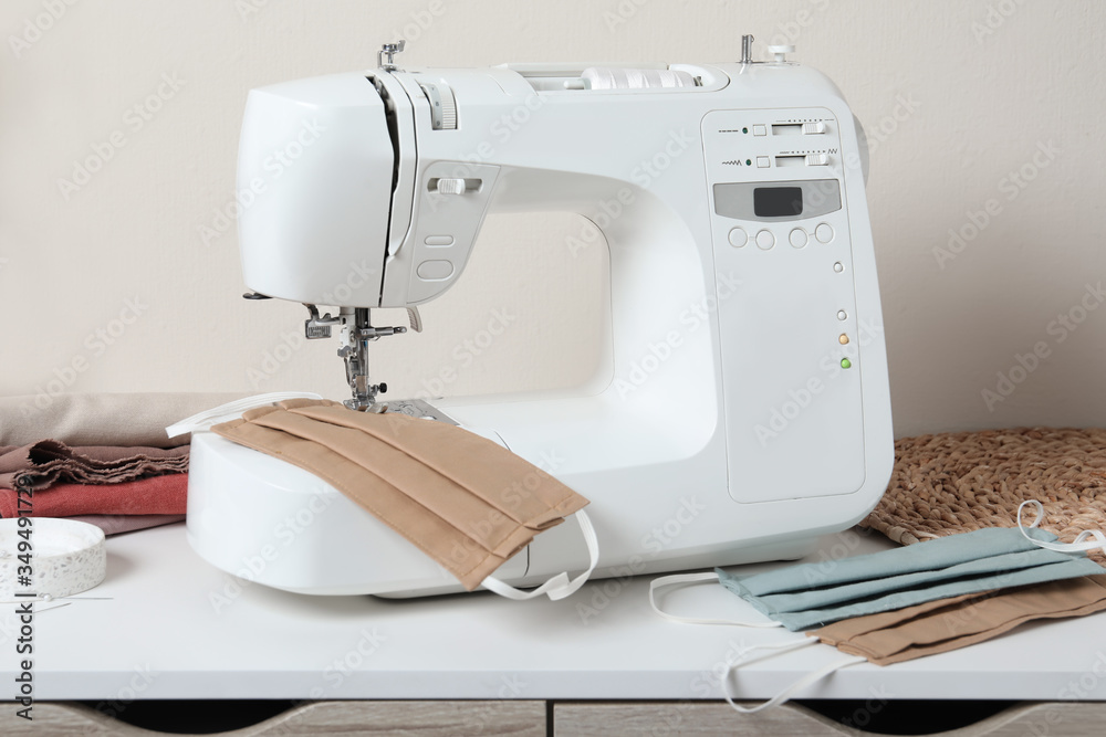 Sewing machine and homemade protective masks on white table
