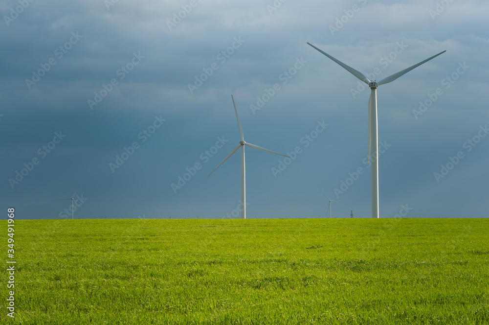 Landscape view of wind power turbine among green meadow with sky in the morning and copy space for text in the sky. Green energy concept. Landscape view of wind power turbine among green meadow with sky in the morning and copy space for text in the sky. Green energy concept.