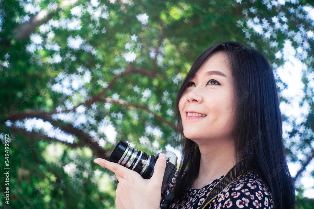 Φωτογραφία Portrait of beautiful smiling asian woman with holding camera at summer green pa
