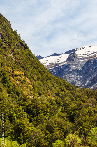 Valley between snowy mountains and hills on the road from Fiordland. South Island, New Zealand