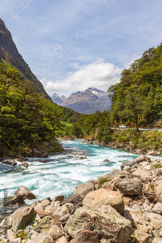 Landscape with a fast river against the background of mountains. Fiordline national park. South Island, New Zealand