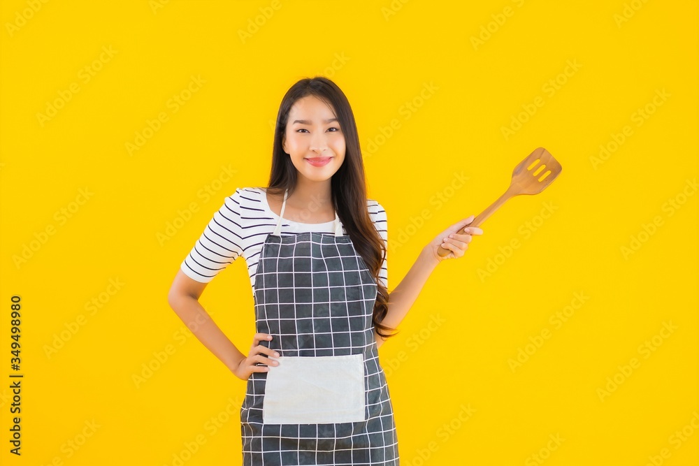 Portrait beautiful young asian woman wear apron with black pan and Spatula Portrait beautiful young asian woman wear apron with black pan and Spatula