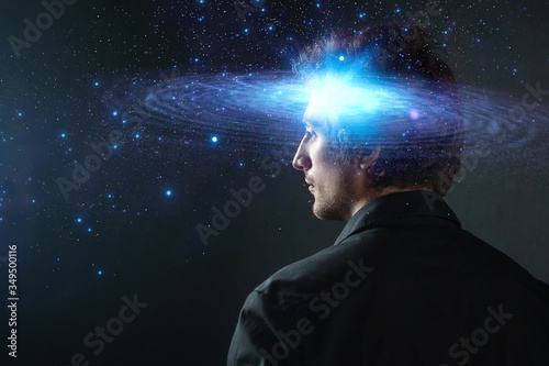 Thoughtful young man, creative mind concept. A man with a galaxy in his head,