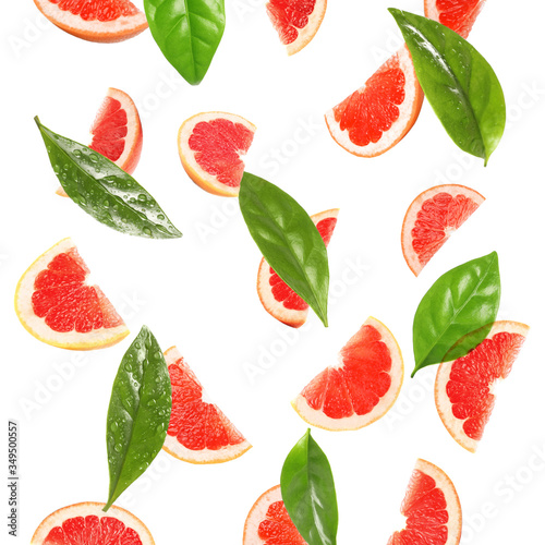 Fototapeta Naklejka Na Ścianę i Meble -  Slices of juicy grapefruit and leaves on white background