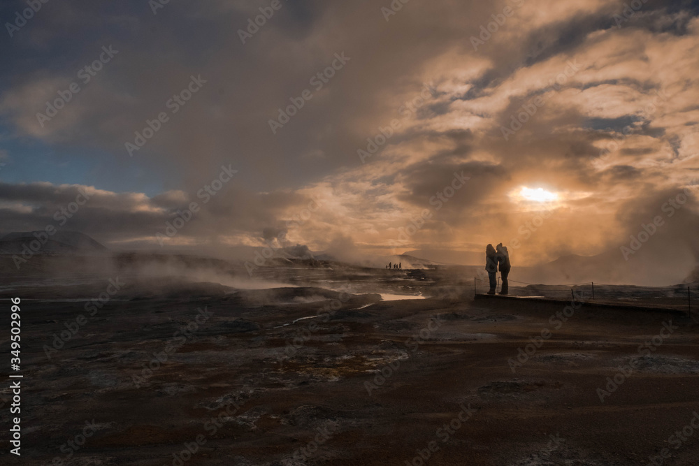 Two tourists amid the water vapor produced by the chimneys of Hverir in Iceland
