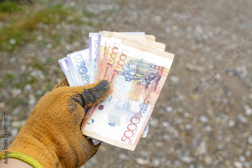 Money in the hands of a working man, received a salary. photo