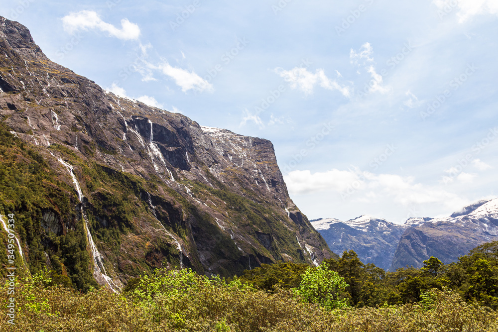 Panorama with a small rock on a background of blue sky on the road in Fiordland. South Island, New Zealand