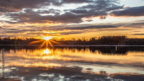 The sun bursts through the clouds at dawn on Blue Marsh Lake in Berks County, PA