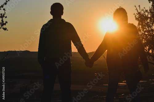 Pareja dándose la mano en una puesta de sol