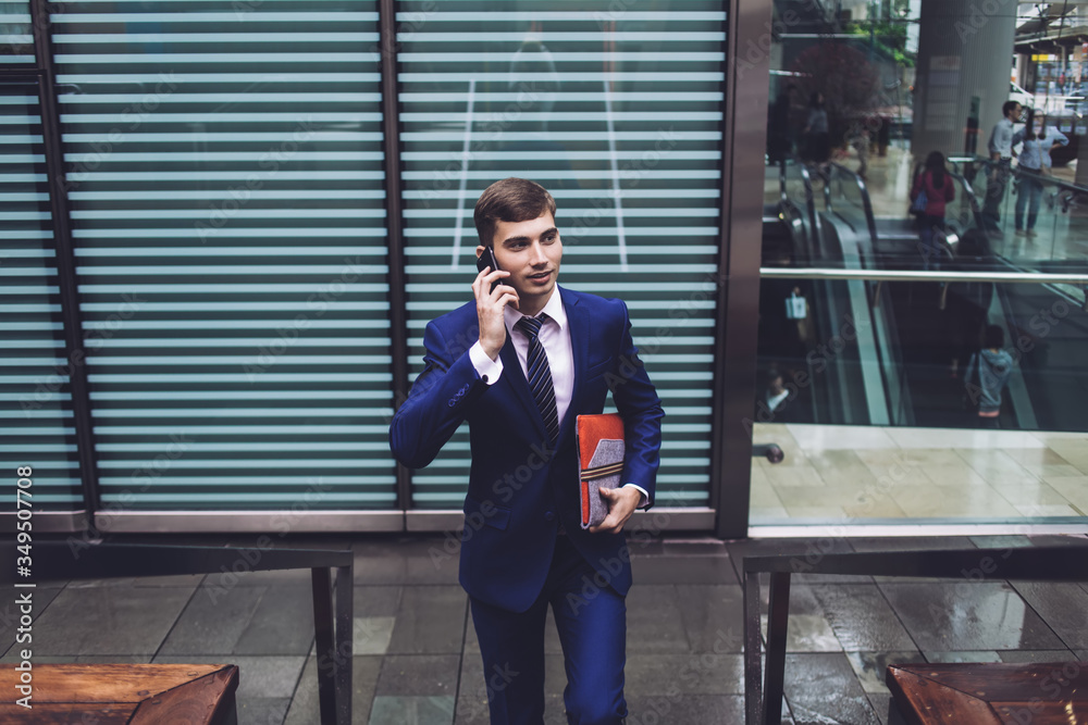 Thoughtful male climbing up stairs in business district and talking on mobile Thoughtful male climbing up stairs in business district and talking on mobile