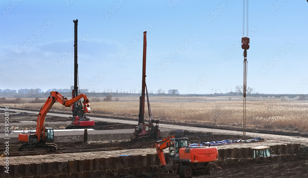 Naklejka premium construction site with construction machines an excavator and piling machine that level the ground and drive piles