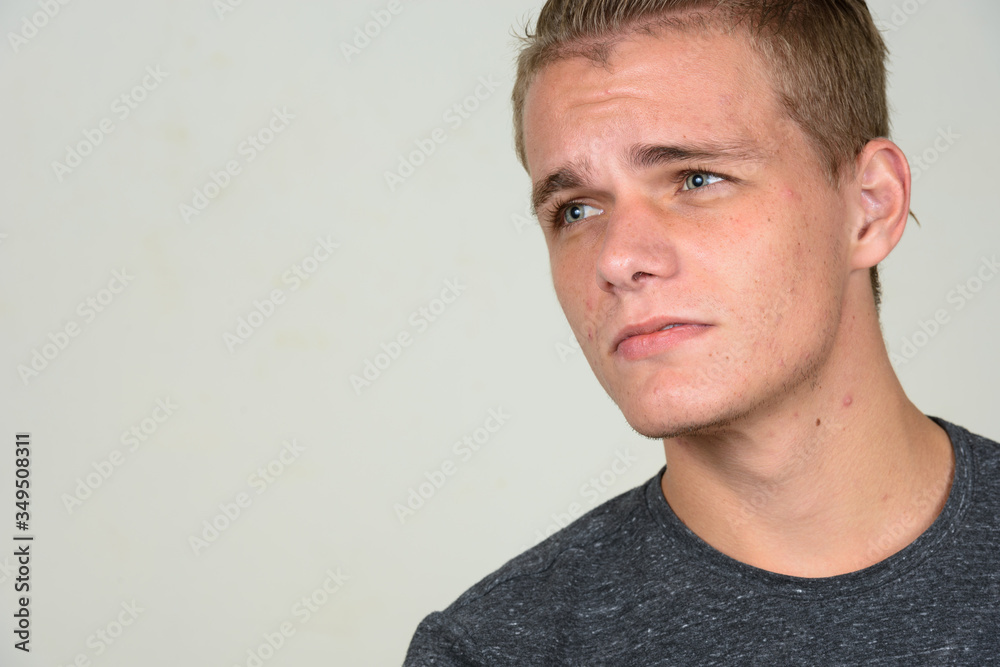 Fototapeta premium Face of young handsome man with blond hair thinking
