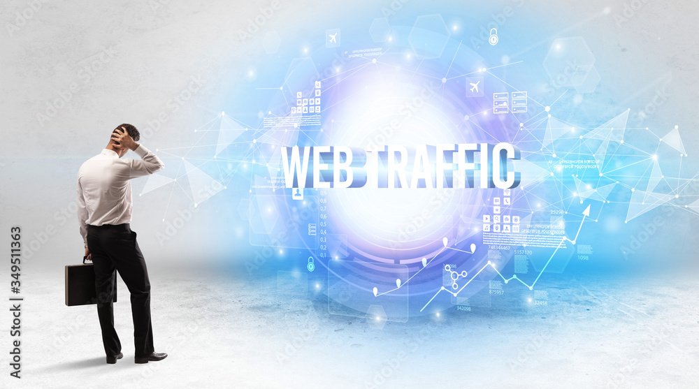 Rear view of a businessman standing in front of WEB TRAFFIC inscription, modern technology concept Rear view of a businessman standing in front of WEB TRAFFIC inscription, modern technology concept