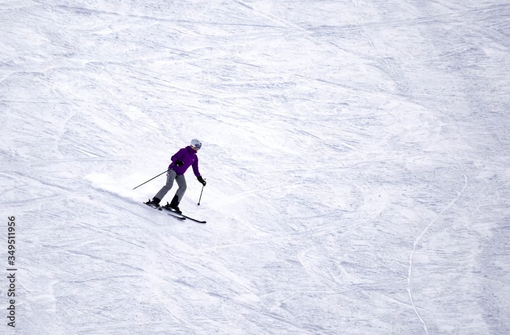 Full length of skier skiing on fresh powder snow. Man skier running downhill on sunny Alps slope Full length of skier skiing on fresh powder snow. Man skier running downhill on sunny Alps slope