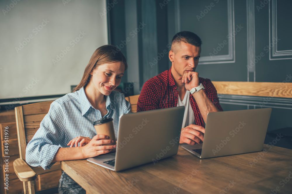 Man and woman using laptops