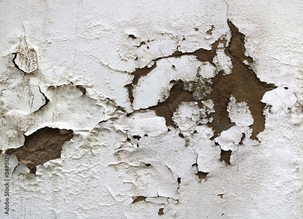 old damaged and dirty white wall with peeling paint rough dirty