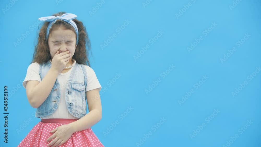 4k slowmotion video where girl with curly hair wants to sleep over blue background. 4k slowmotion video where girl with curly hair wants to sleep over blue background.
