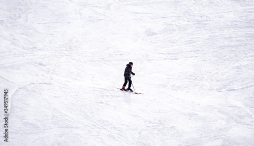 Full length of skier skiing on fresh powder snow. Man skier running downhill on sunny Alps slope