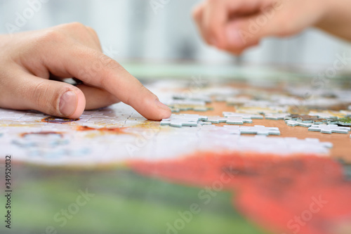 Close-up of children's hands collecting jigsaw puzzles