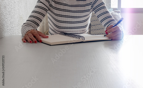 Unrecognizable student handwriting in notebook, with copy space. Homeschooling, learning at home.