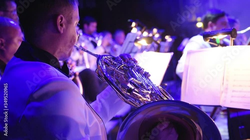 A man plays a wind instrument in an orchestra, a Helikon bass in the hands of a musician