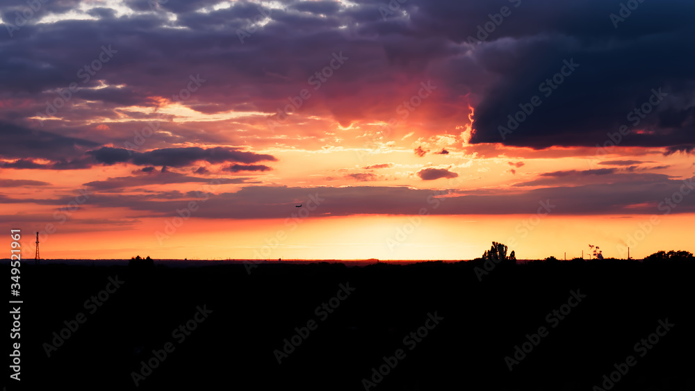 A landing plane during an amazing sunset