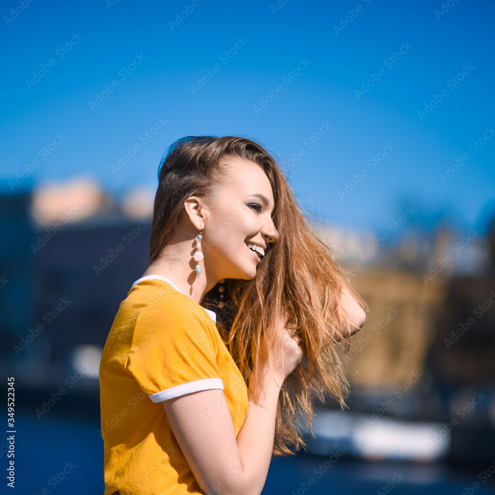 close-up portrait of a young girl hipster beautiful blonde  with blue skirt laughing and posing against the backdrop of the St. Petersburg city