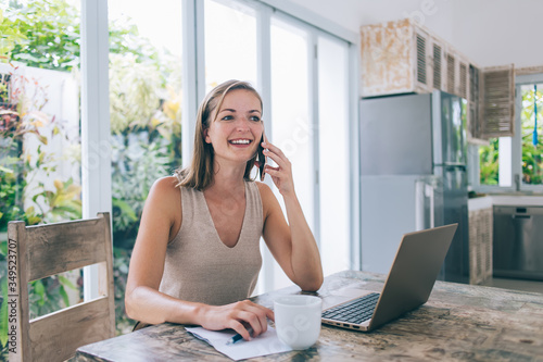 Adult businesswoman talking on phone at home workplace © GalakticDreamer