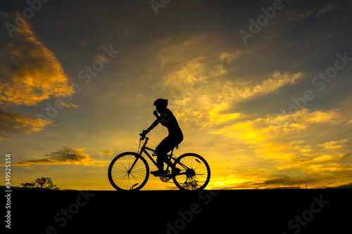 Action of cyclist and Bicycle silhouettes on the dark background of sunsets