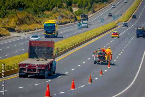 Cotopaxi, ECUADOR - 08 September 2019: Workmen painting lines on road. Road line car painting white lines and central road line marking.