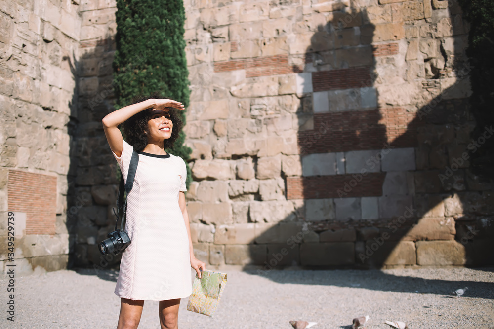 Happy ethnic woman exploring old city