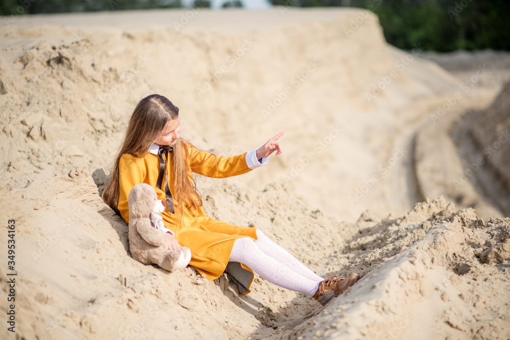 young woman in a yellow dress. little girl playing on the beach. young woman with teddy bear. young woman in a yellow dress. little girl playing on the beach. young woman with teddy bear.