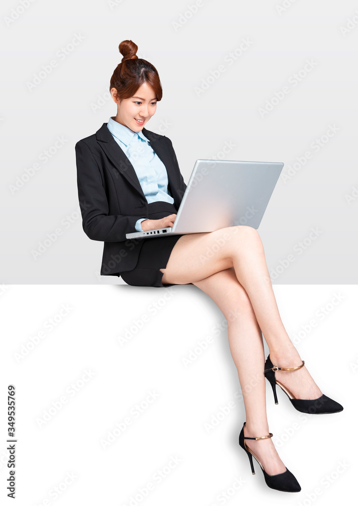 young Business woman with laptop sitting on blank billboard placard sign young Business woman with laptop sitting on blank billboard placard sign