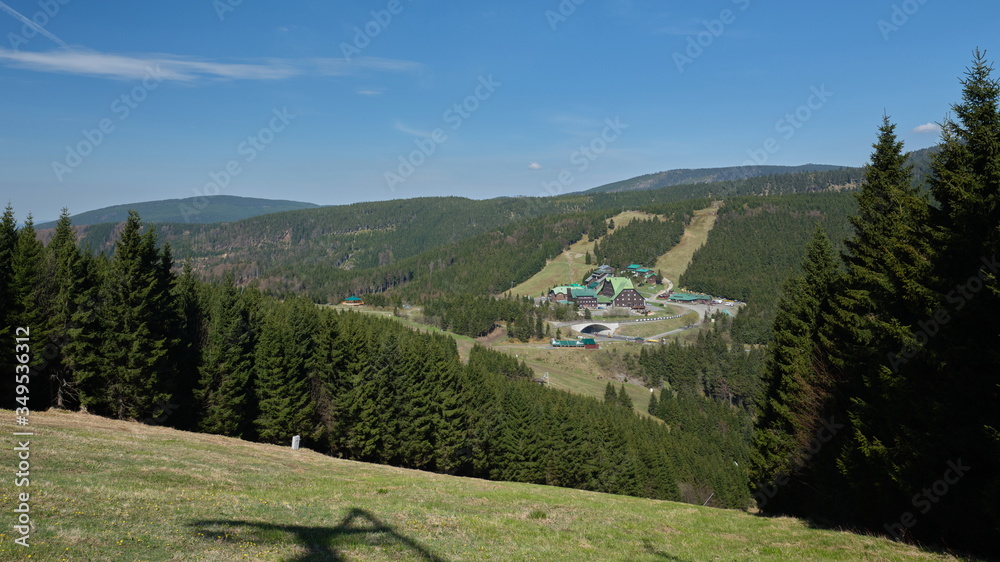 Fototapeta premium Mountain huts on a road at mountain pass on a sunny cloudless spring day.