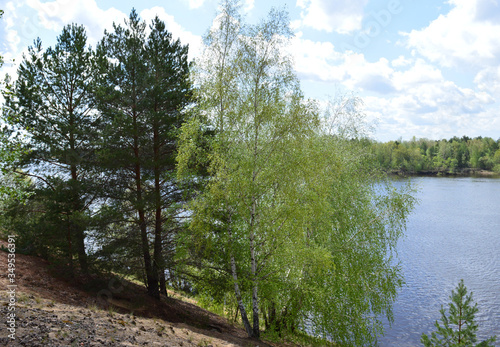 natural background blue sky with white clouds in clear weather on a summer day and a fishing rod on the river Bank for fishing