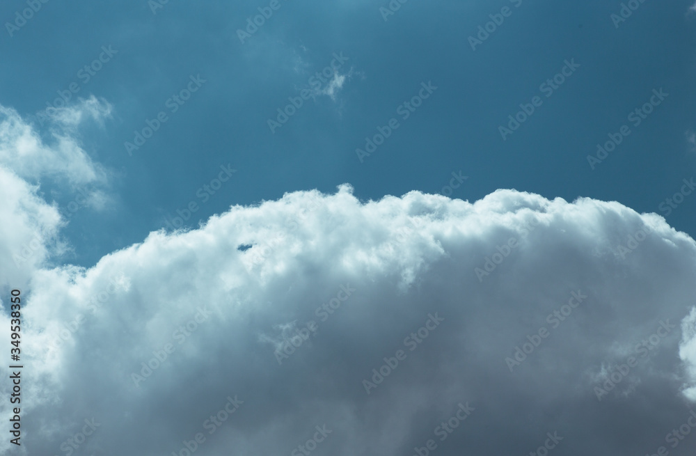 Obraz premium Fluffy clouds cover the summer blue sky