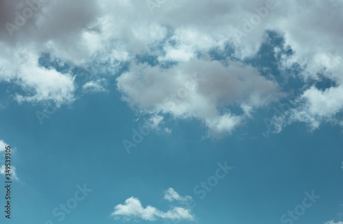 Fluffy clouds cover the summer blue sky