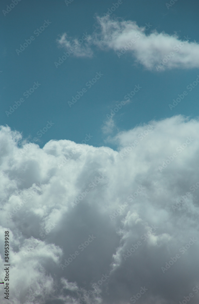 Fluffy clouds cover the summer blue sky