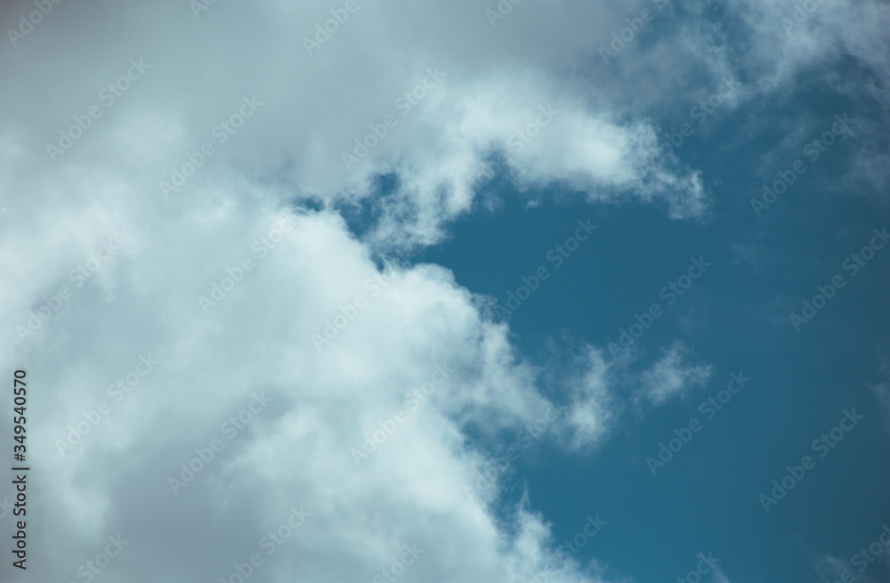 Fluffy clouds cover the summer blue sky