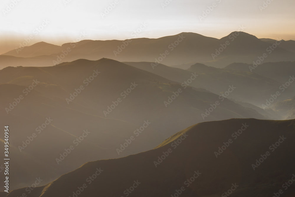 Sunrise in the Pyrenees mountains. The ridges and ridges of the mountains in the misty morning haze at dawn. Incredible landscape on the path of Santiago. Hiking trail in spain. Way of Saint James.