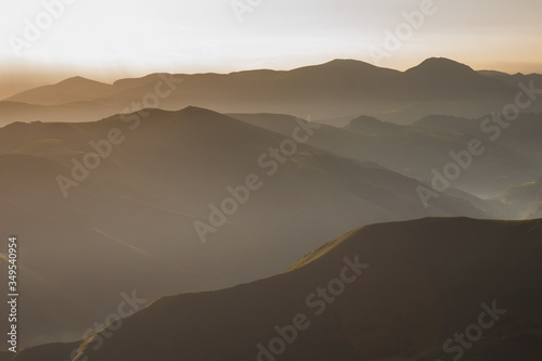 Sunrise in the Pyrenees mountains. The ridges and ridges of the mountains in the misty morning haze at dawn. Incredible landscape on the path of Santiago. Hiking trail in spain. Way of Saint James.