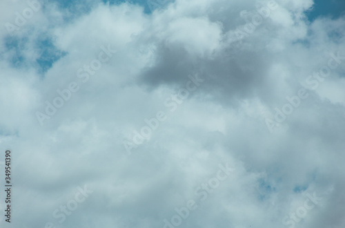 Fluffy clouds cover the summer blue sky