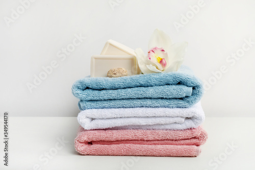 Soap and white orchid flower on stack of bath towels on white background
