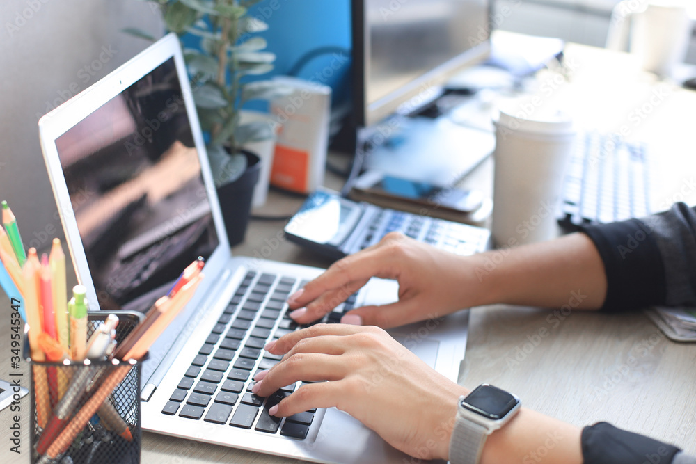 Woman hands pressing keys on a laptop keyboard in office. Woman hands pressing keys on a laptop keyboard in office.