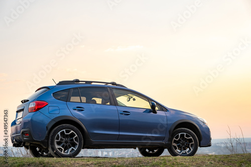 Landscape with blue off road car at sunset, Traveling by auto, adventure in wildlife, expedition or extreme travel on a SUV automobile. Offroad 4x4 vehicle in field at sunrise. © bilanol