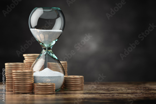 Golden coins and hourglass clock. Return on investment, deposit, growth of income and savings, time is money concept.
